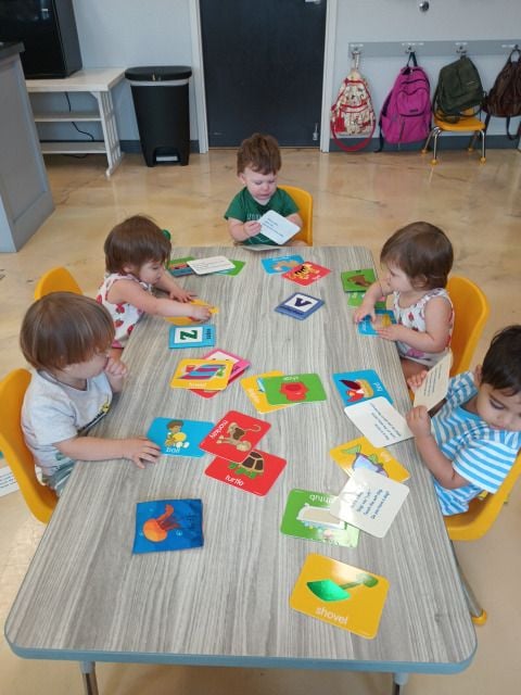 Montessori infant exploring wooden toy in calm, organized early childhood classroom.